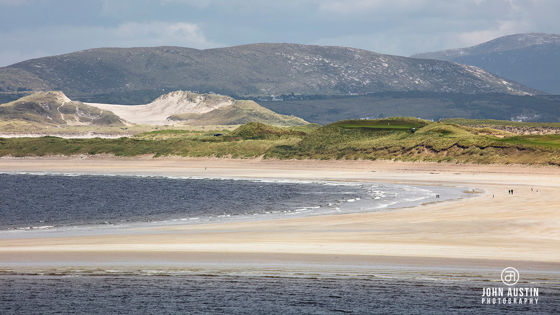 a photograph of Portnoo Strand in County Donegal, Ireland is summer sunshine and people strolling on the beach