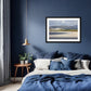 a framed fine art photographic print of Portnoo Strand in County Donegal hanging on a wall above a bed