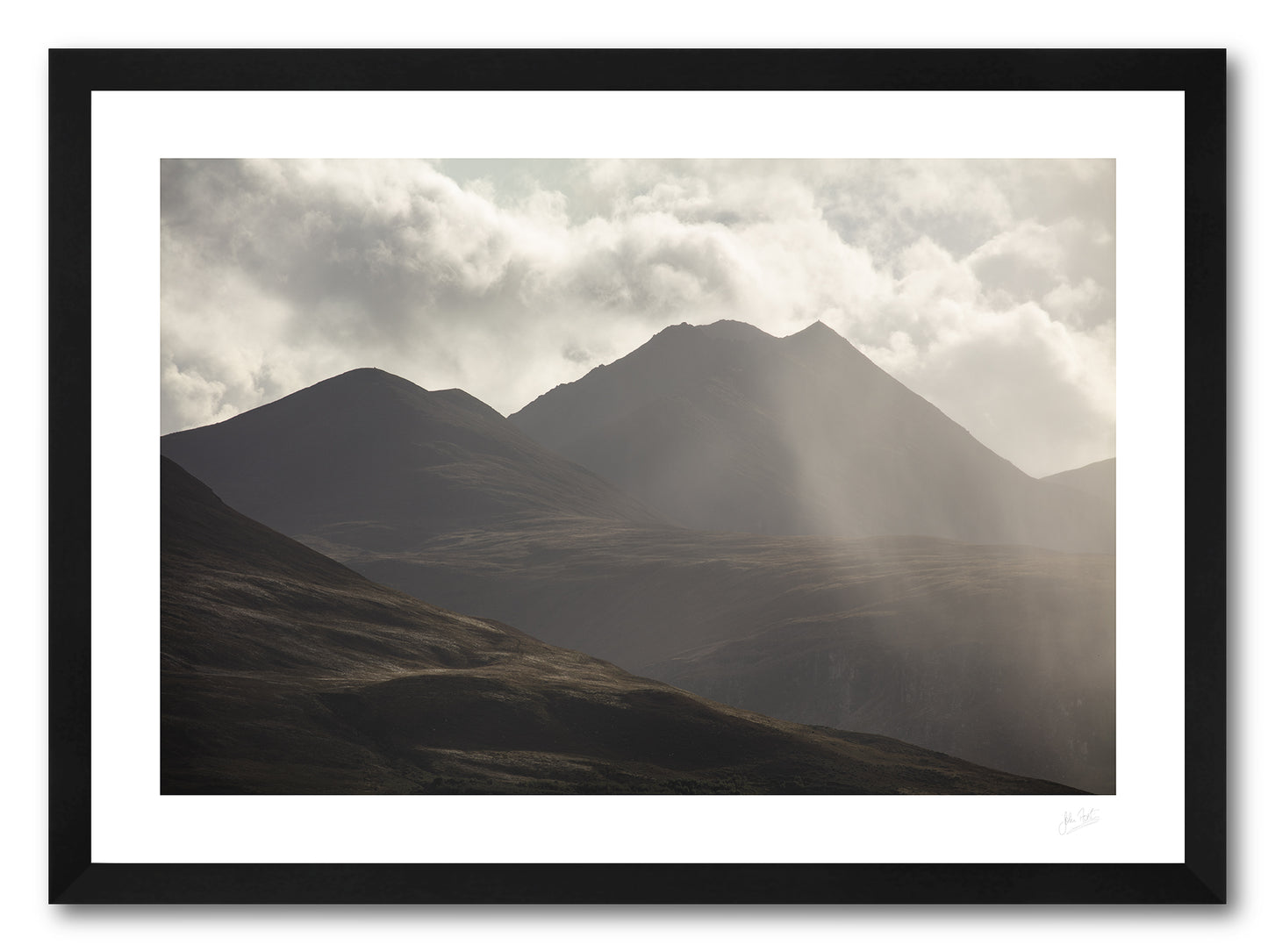 a framed fine art photograph of A dramatic view of the eastern edge of The MacGillycuddy's Reeks, Ireland's highest mountain range with the peak of Cruach Mhor visible against a bright cloudy sky