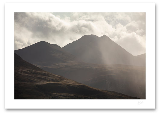 an unframed fine art photograph of A dramatic view of the eastern edge of The MacGillycuddy's Reeks, Ireland's highest mountain range with the peak of Cruach Mhor visible against a bright cloudy sky