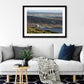 a framed fine art photographic print of a connemara pony overlooking the connemara coastline hanging on a living room wall above a sofa, available to buy online