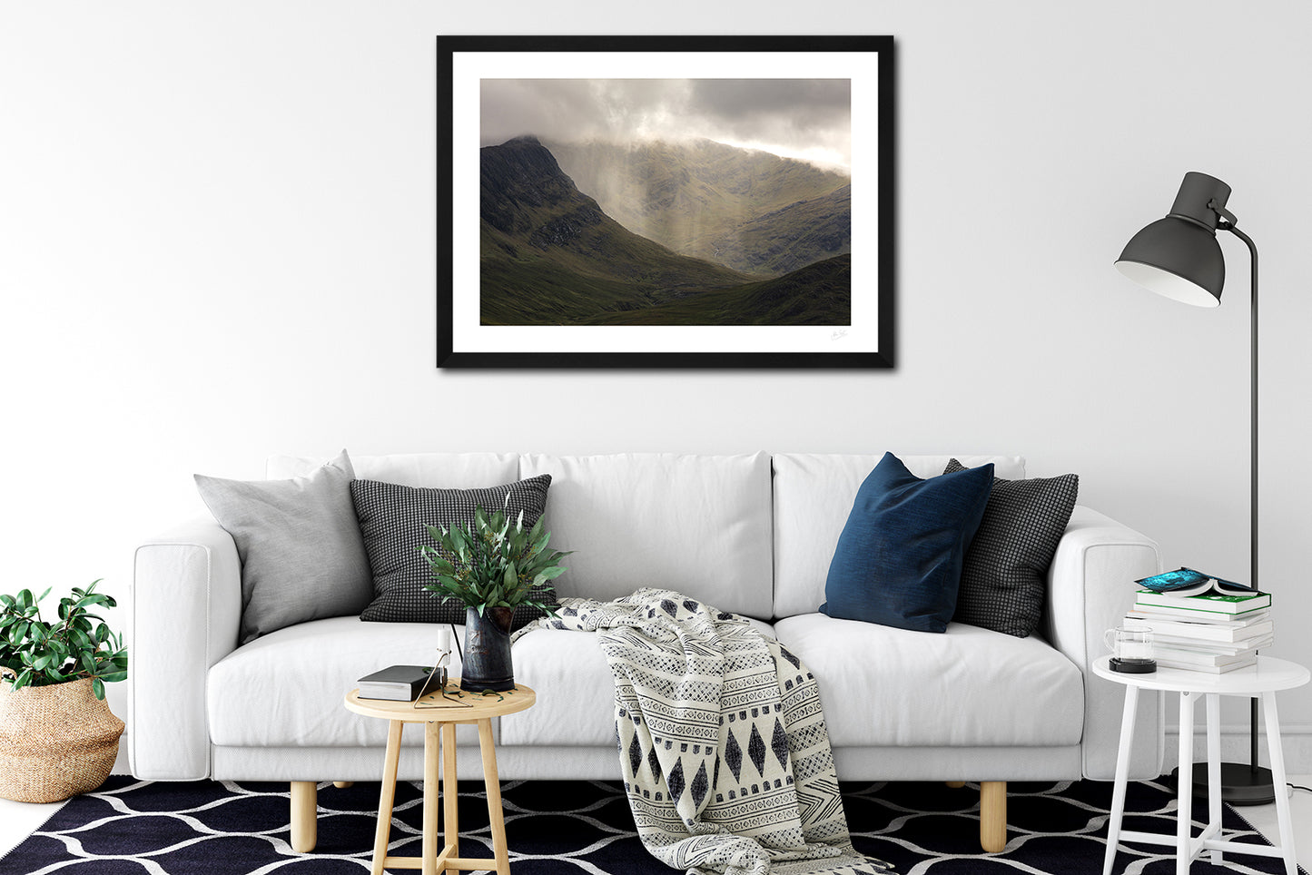 a framed fine art photographic print of a rain shower on the peak of Ben Gorm mountain in Mayo, hanging on a wall above a white sofa