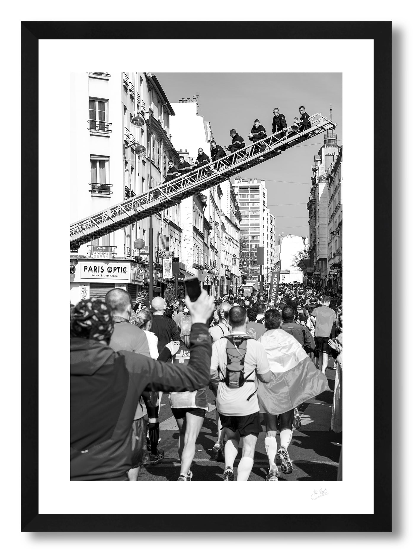 a framed fine art photographic print of Parisian firemen sitting on a ladder above a Paris street during the Paris Marathon to support the runners, available to buy online