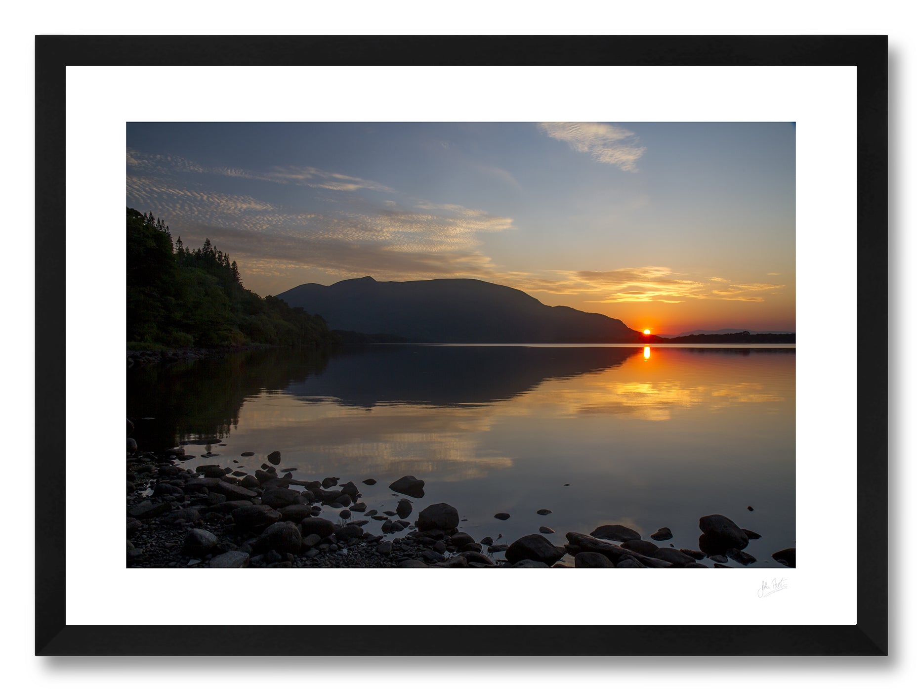 a framed fine art photographic print of the summer sun setting behind Shehy mountain across a calm Muckross Lake in Killarney National Park, available to buy online