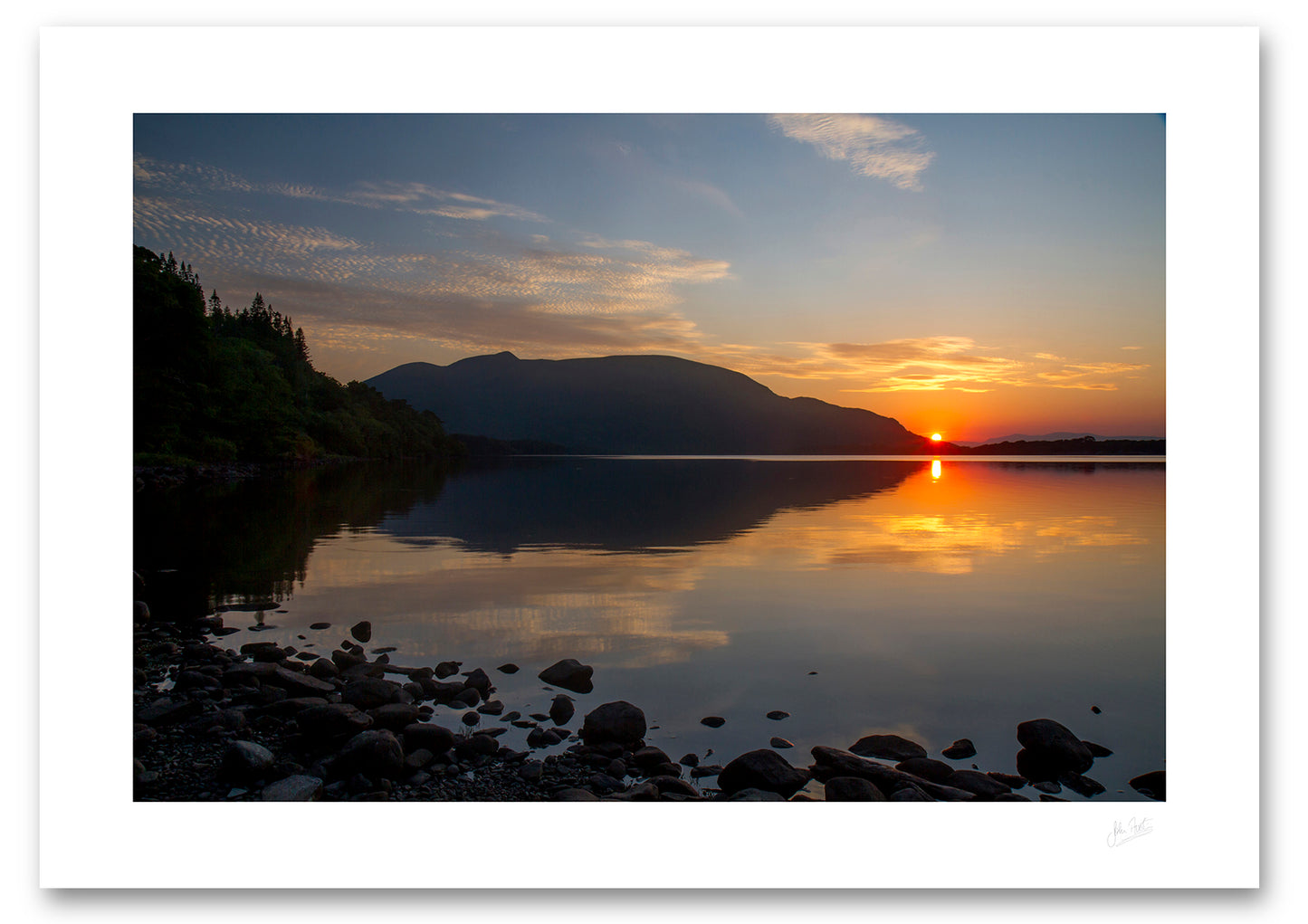 an unframed fine art photographic print of the summer sun setting behind Shehy mountain across a calm Muckross Lake in Killarney National Park, available to buy online