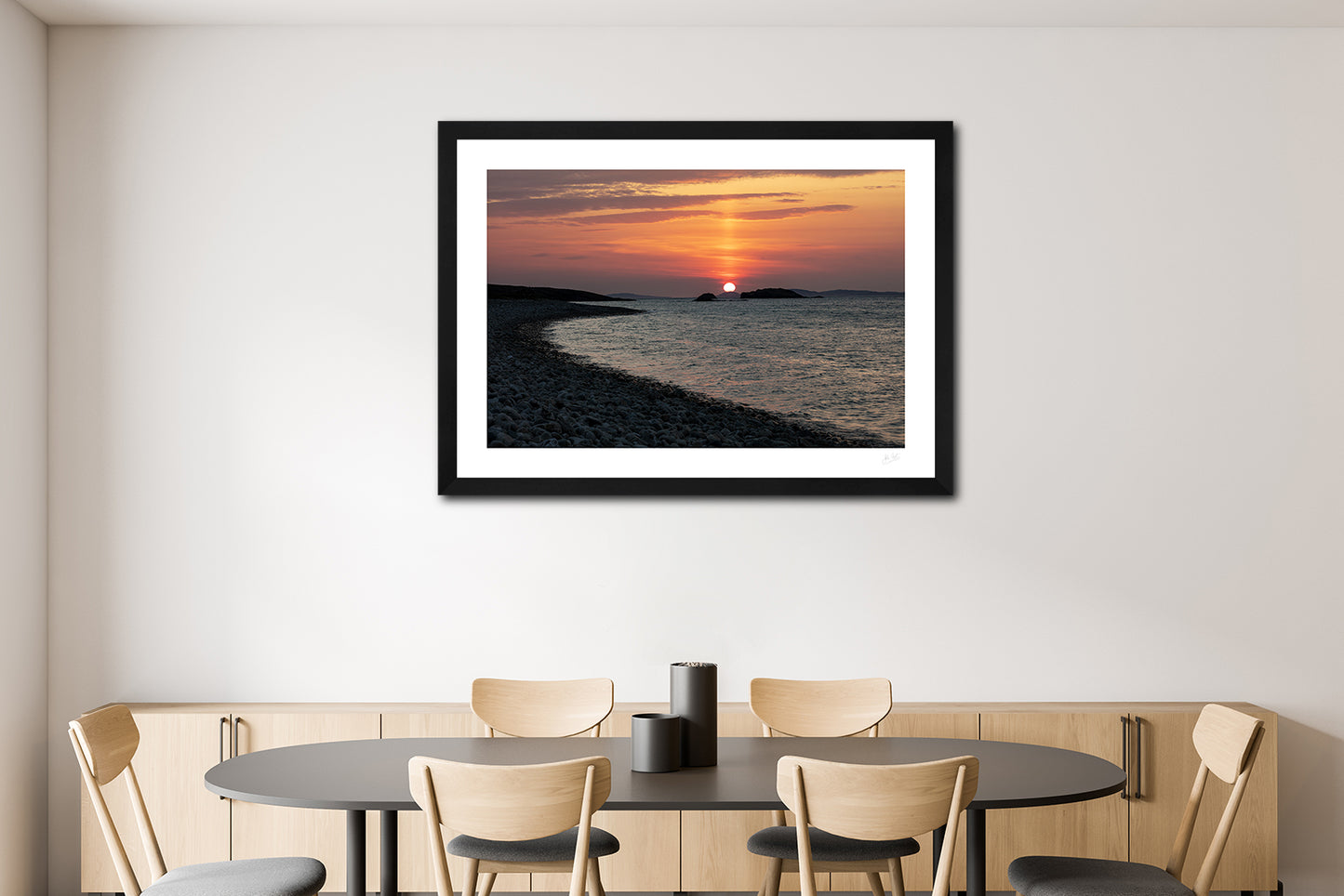 a framed fine art photographic print of a beautiful sunset from a silhouetted Ross Beach in Connemara as the sun sets behind Inishbofin Island hanging on a dining room wall