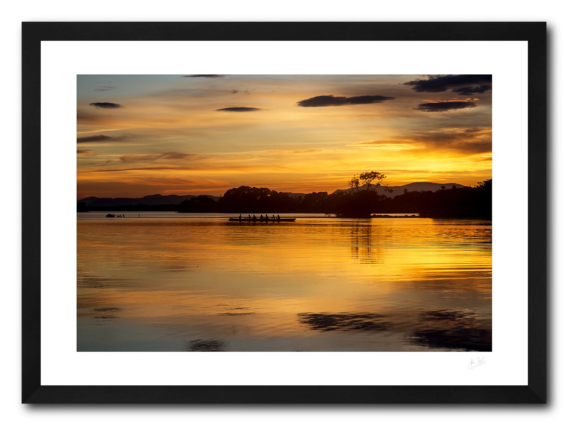 a framed fine art photographic print of a boat of rowers on Lough Leane, Killarney surrounded by the beautiful colours of a summer sunset, available to buy online