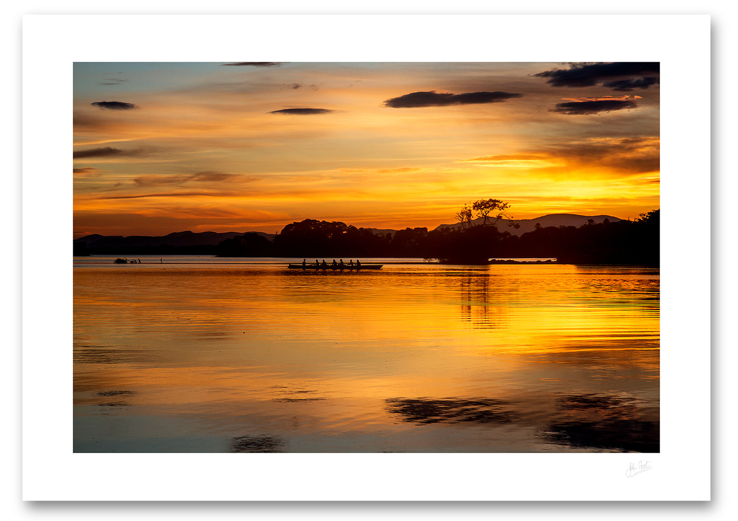 an unframed fine art photographic print of a boat of rowers on Lough Leane, Killarney surrounded by the beautiful colours of a summer sunset, available to buy online